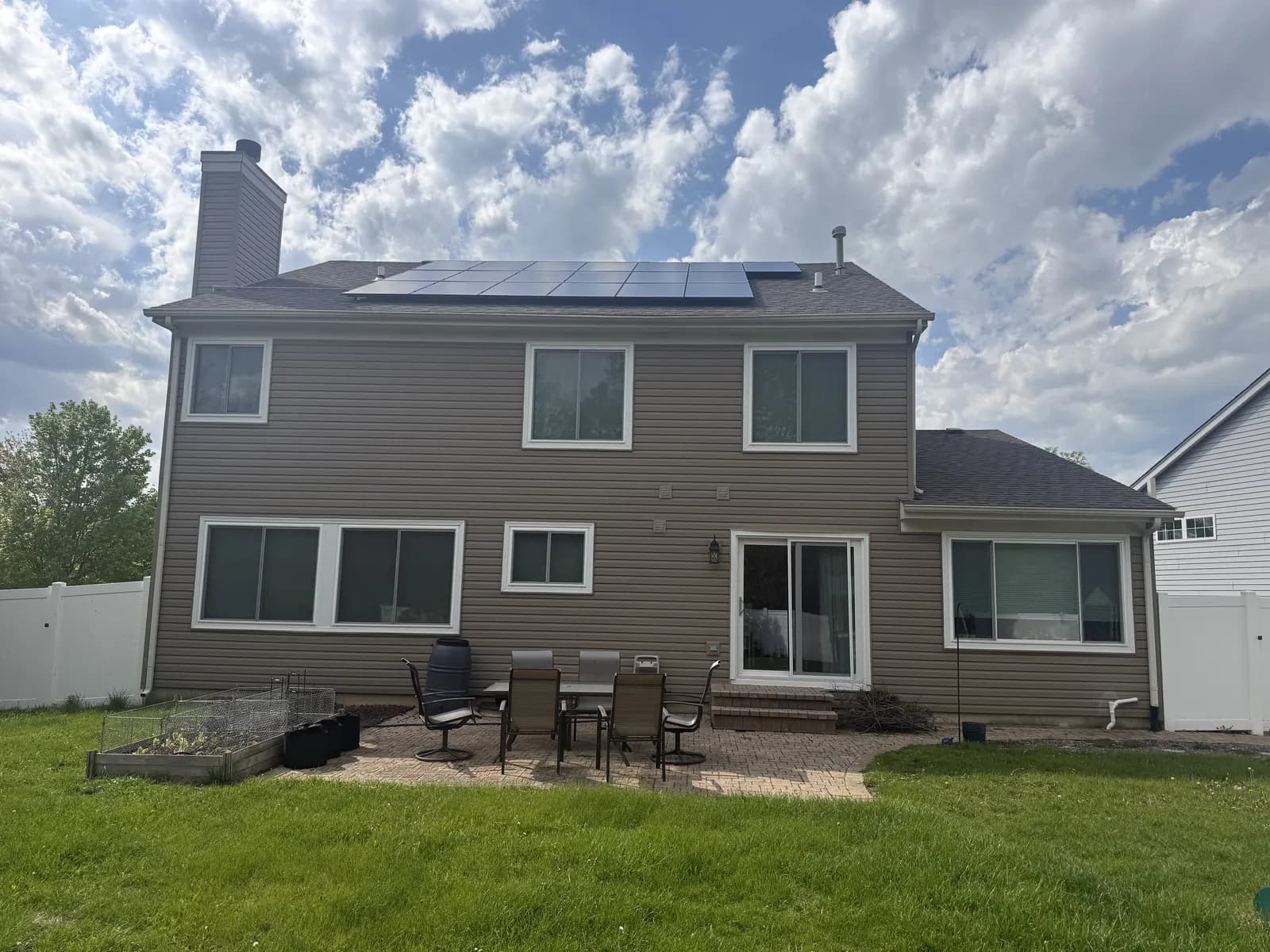 Two-story home with new white-trimmed windows and a sliding patio door